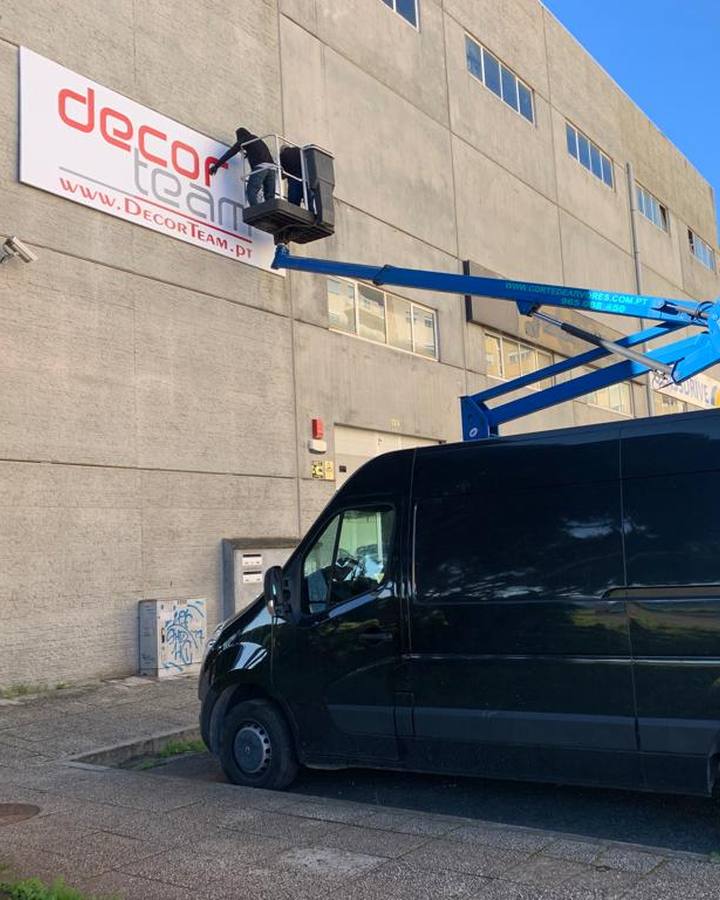 Instalação de reclamo exterior em fachada de edifício com plataforma elevatória